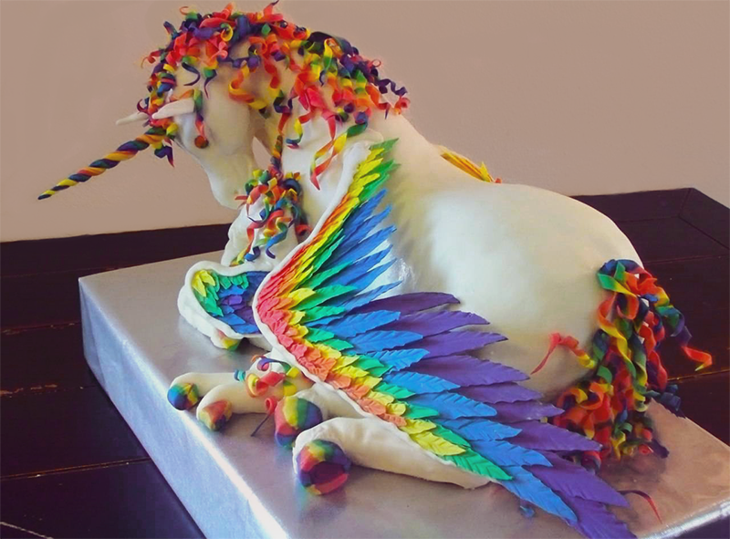 Étonnant dessin de gâteau représentant une licorne multicolore grandeur nature.