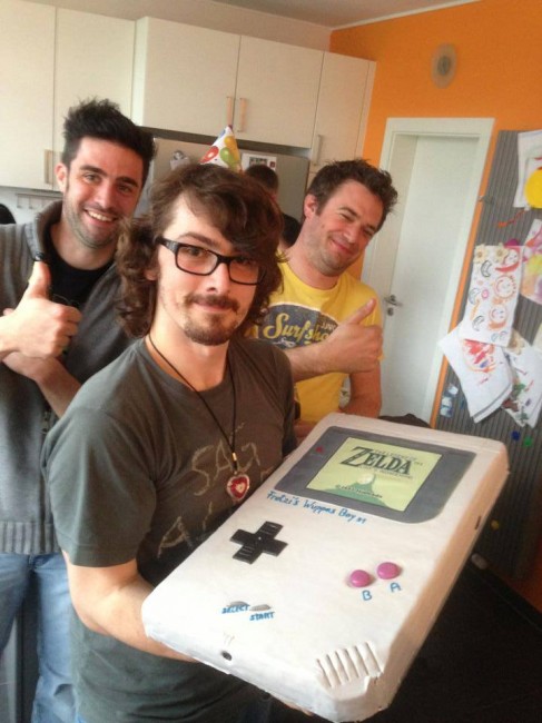 Wuppes tenant un gâteau Game Boy géant