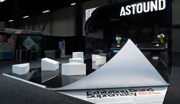 Astound exhibition booth featured the flooring seemingly peeling back revealing text that reads 'exhibiting brand supremacy'