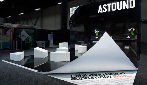 Astound exhibition booth featured the flooring seemingly peeling back revealing text that reads 'exhibiting brand supremacy' 