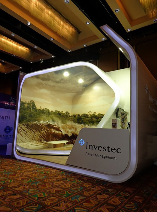 Investec exhibition stand swirls round and has an image throughout it that looks like an ocean and you sit on a surfboard
