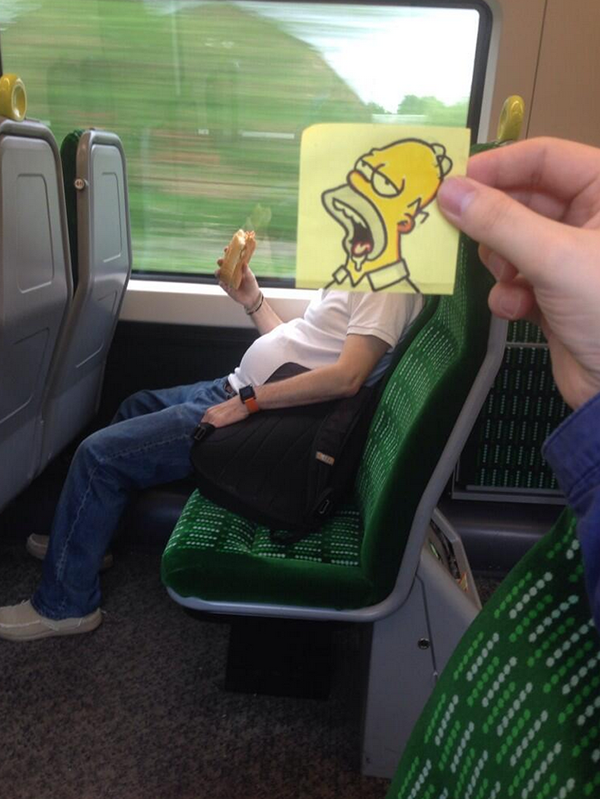 Funny sketch of Homor, from the Simpson's, face with drool on top of a real life guy who eating a sandwich on the train