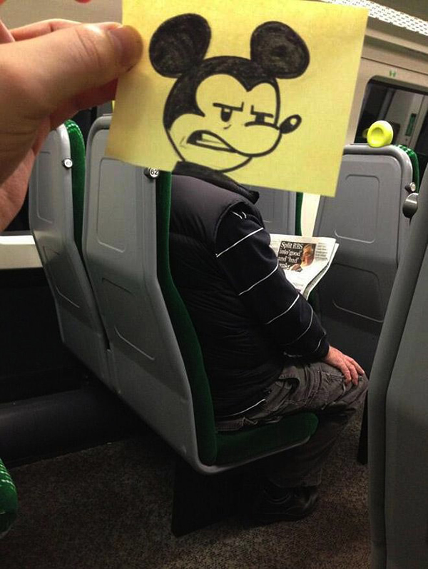 Clever sketch of an angry looking Mickey Mouse head reimposed on an unsuspecting commuter