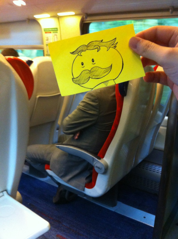 Funny sketch of the Pringles guy drawn onto a sticker and put put on a businessman's body on the train to work