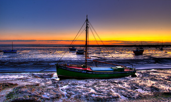 Absolutely stunning photo of Southend's Thames estuary with a sky sunset of deep blues and yellows and the tide is out