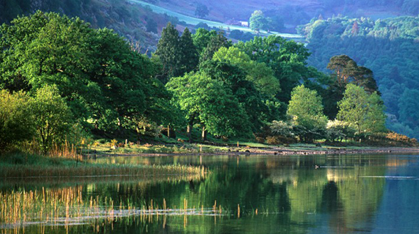 Beautiful landscape photograph taken from Southend Photo Society showing a still, calm lake with a valley backdrop - stunning mixture of greens, blues and yellows.