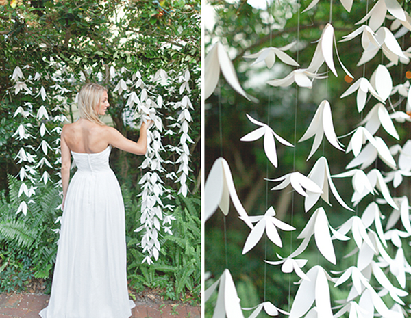 Beautiful wedding white paper craft garland hanging from a tree shaped like lillies