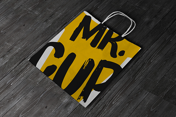 MR. CUP paper bag - branding has a massive 'MR. CUP' written on the bag in black with yellow and white background